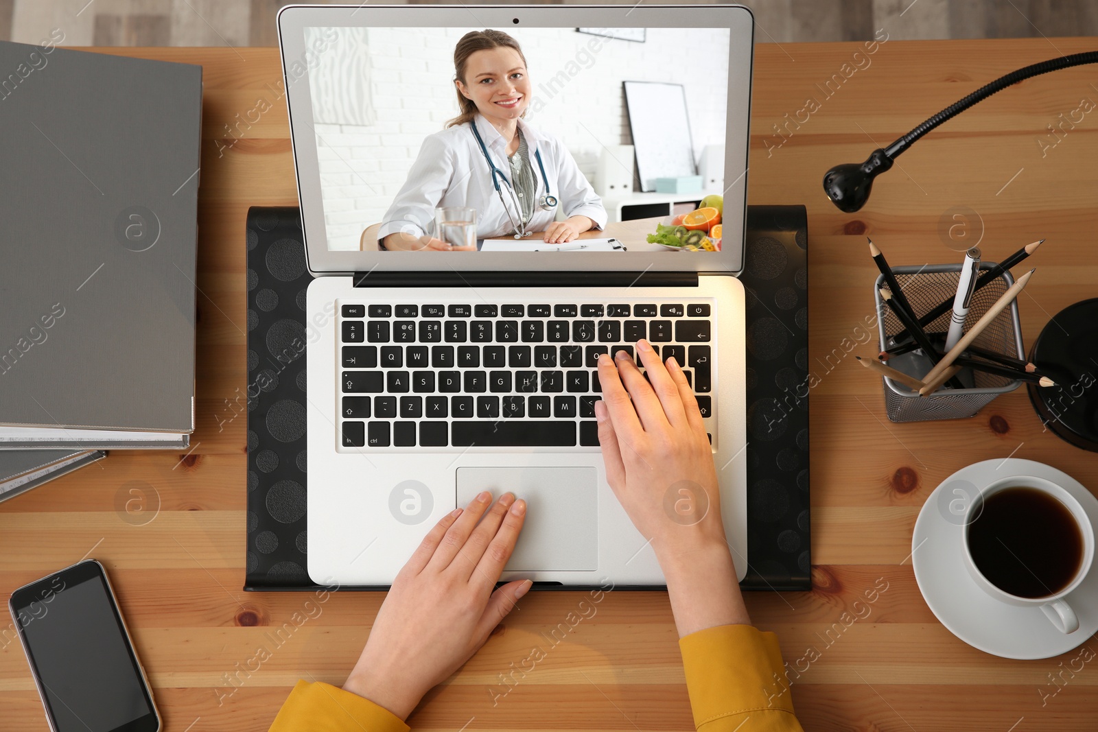 Image of Woman using laptop for online consultation with nutritionist via video chat, top view