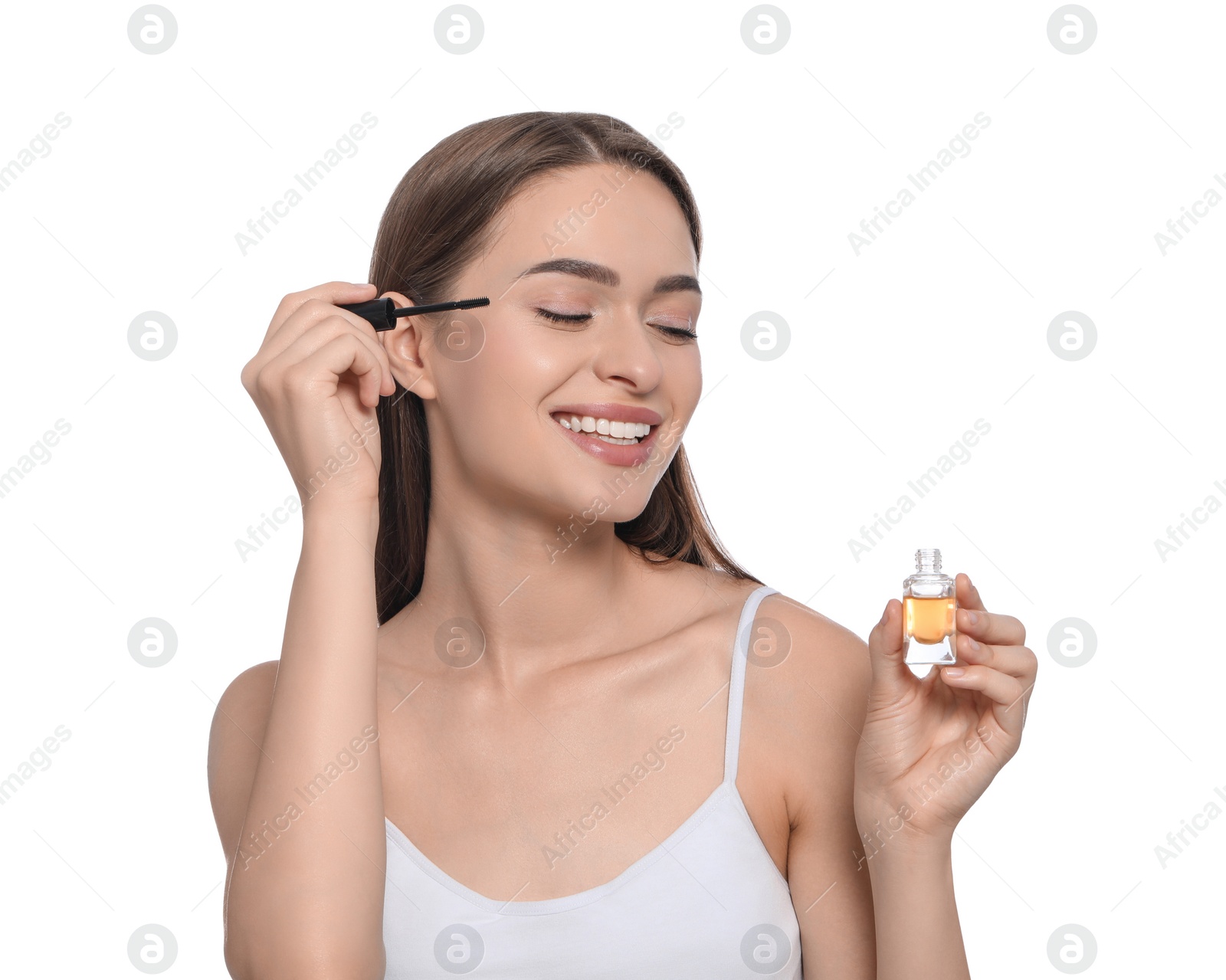 Photo of Young woman with eyelash oil on white background