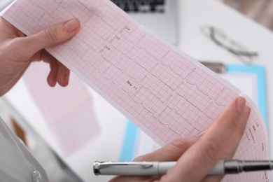 Photo of Doctor examining cardiogram in medical clinic, closeup