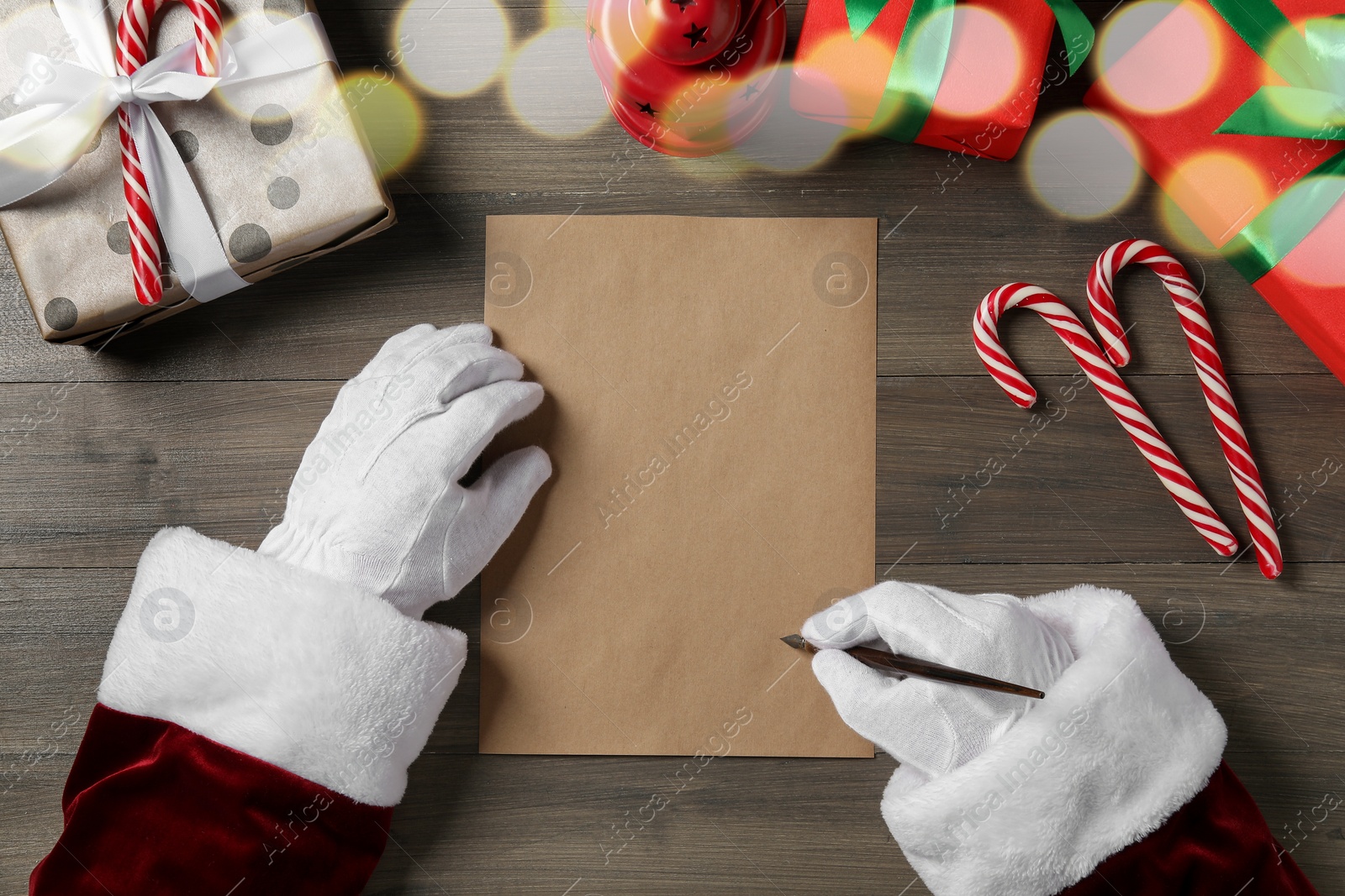 Photo of Santa Claus writing letter with fountain pen at wooden table, top view. Space for text