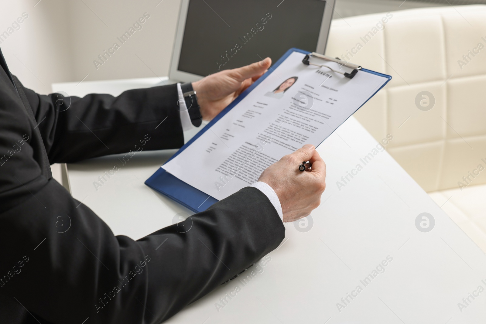 Photo of Human resources manager reading applicant's resume in office, closeup