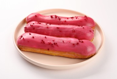 Delicious eclairs covered with glaze on white background,