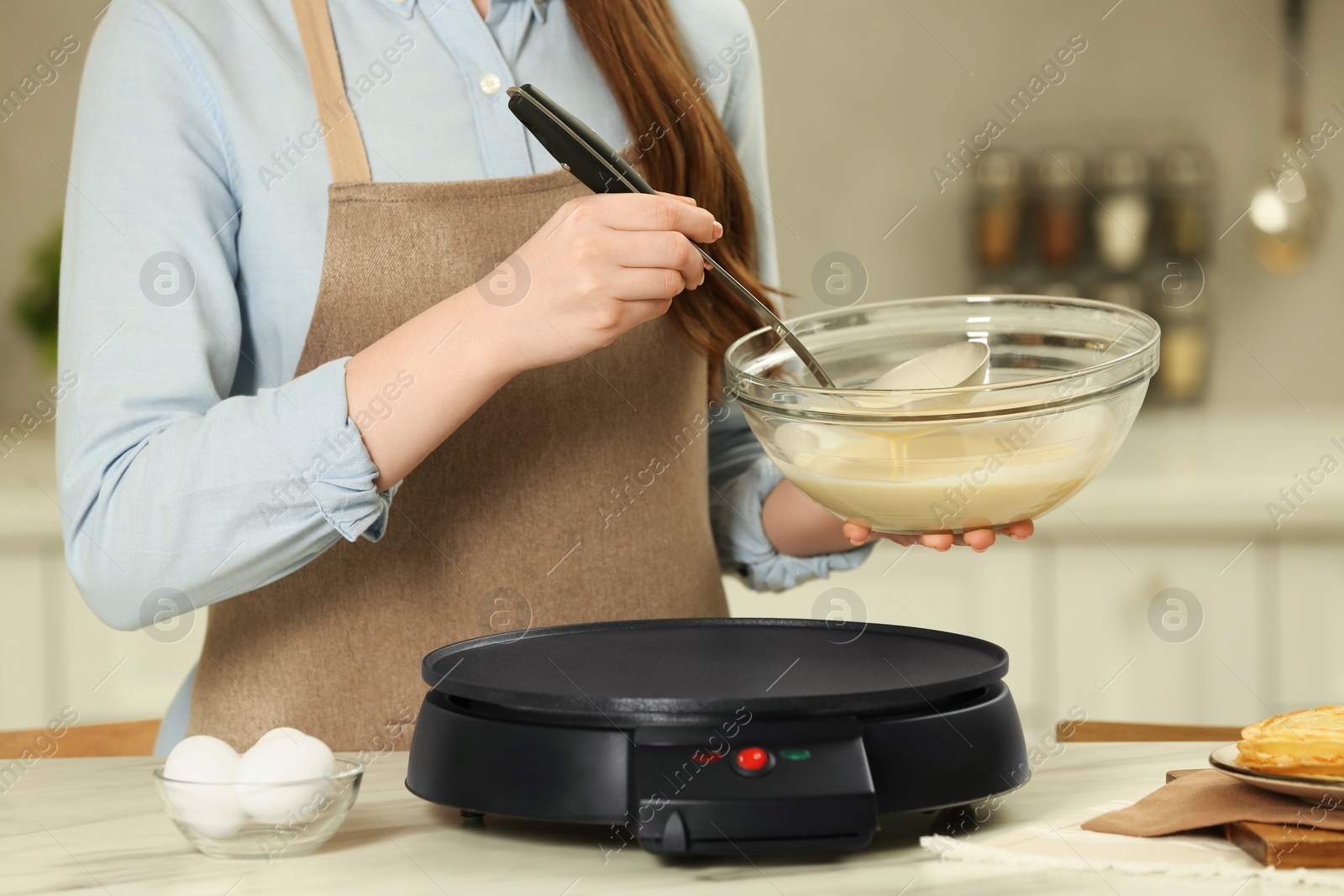 Photo of Woman with dough for crepes at white marble table in kitchen