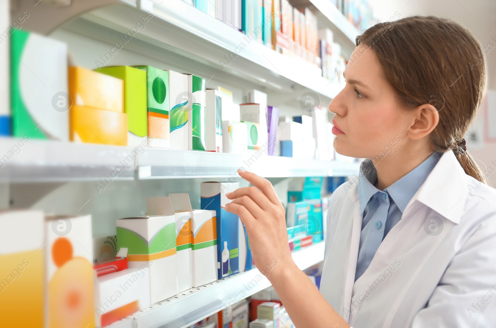 Image of Professional pharmacist near shelves in modern drugstore