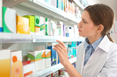 Professional pharmacist near shelves in modern drugstore