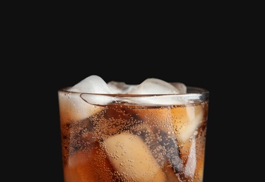Glass of tasty refreshing cola with ice cubes on black background, closeup