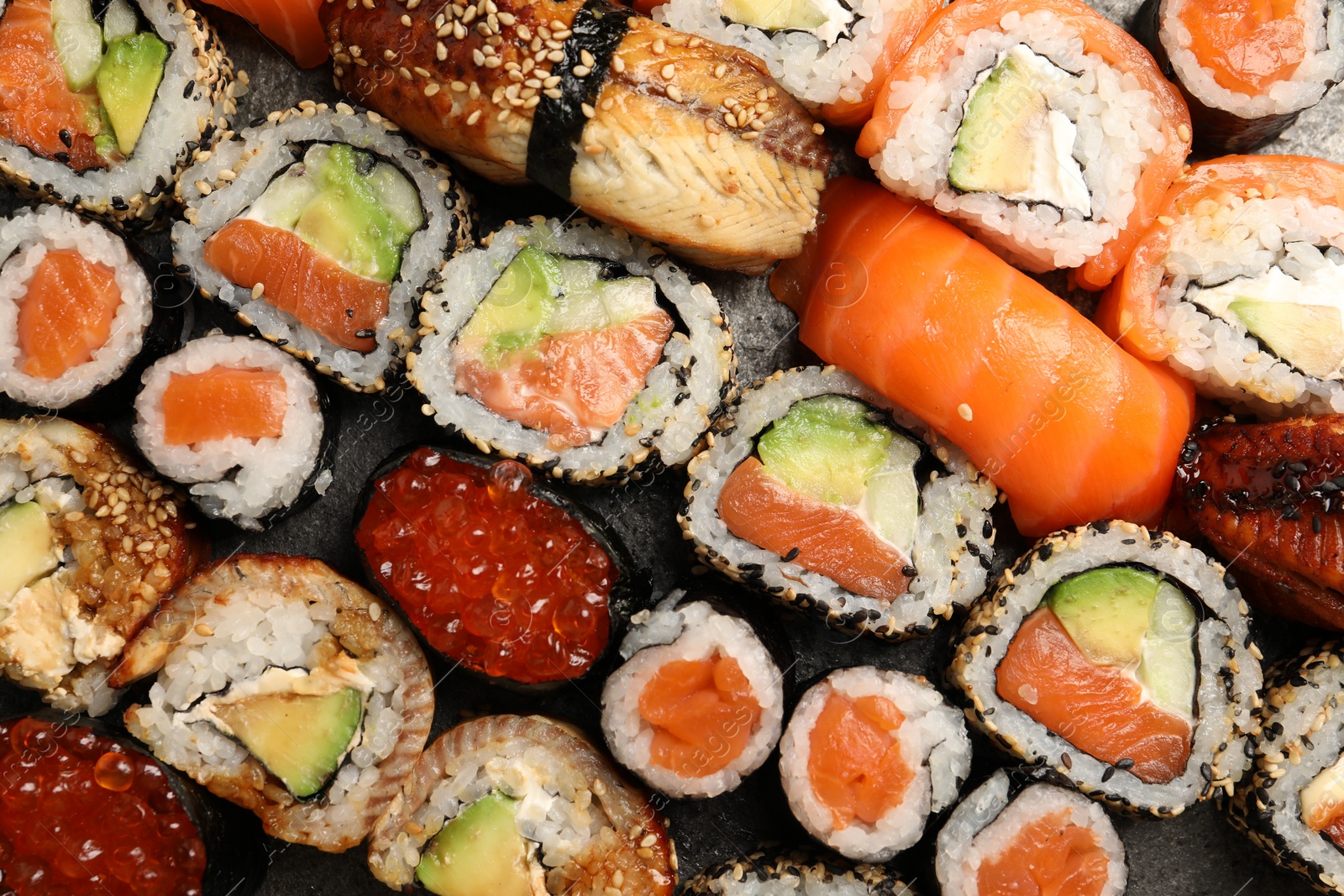 Photo of Different tasty sushi rolls as background, top view