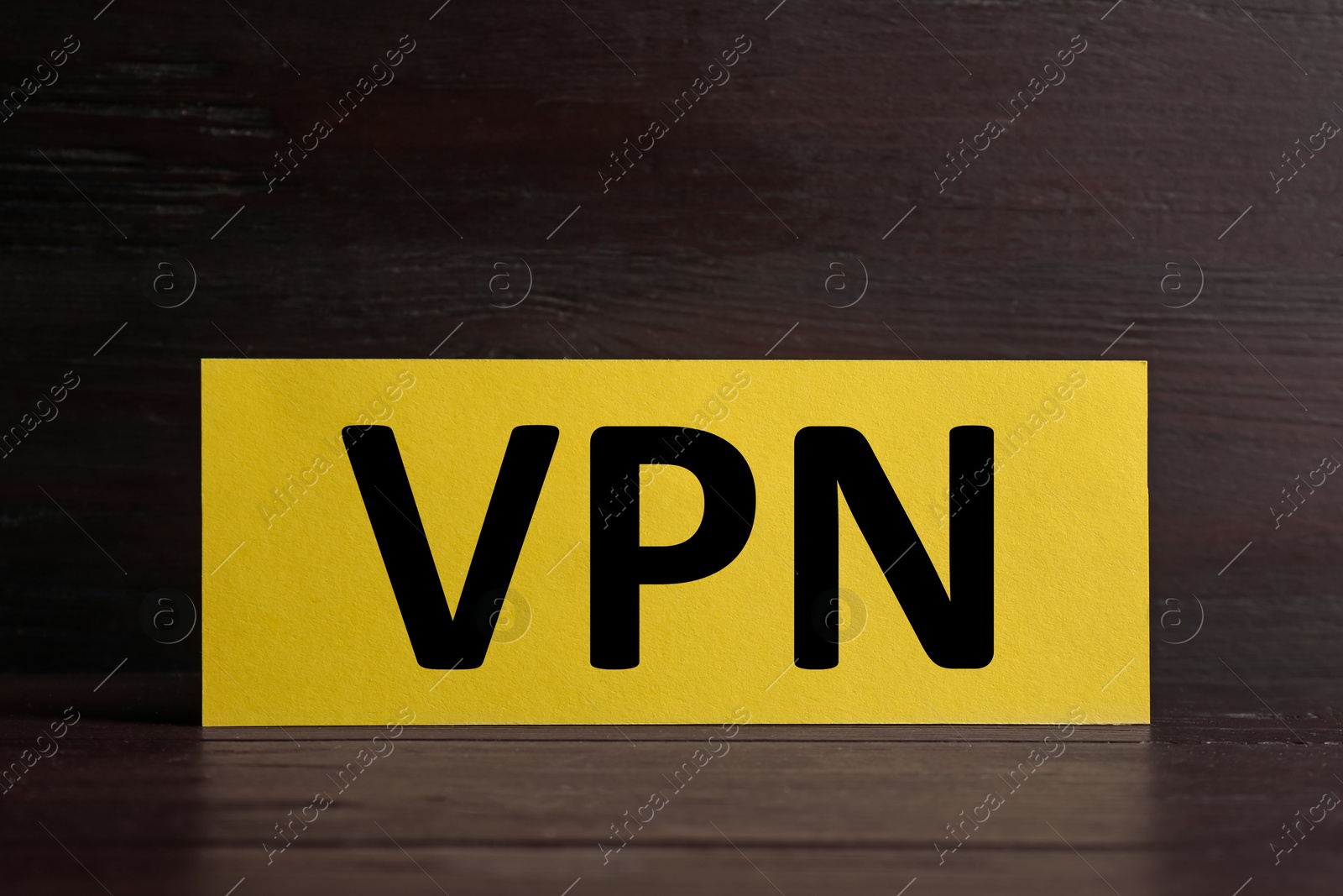 Photo of Yellow card with acronym VPN on wooden table