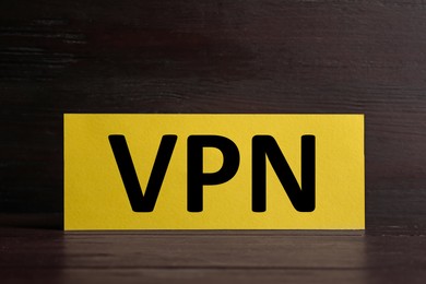 Photo of Yellow card with acronym VPN on wooden table