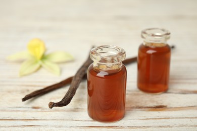 Photo of Aromatic homemade vanilla extract on white wooden table