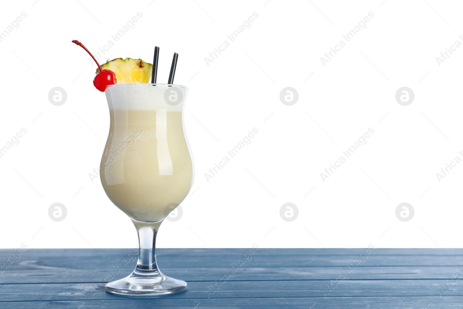 Photo of Tasty Pina Colada cocktail on blue wooden table against white background, space for text