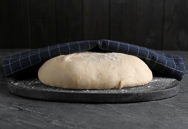 Fresh yeast dough with flour on black table