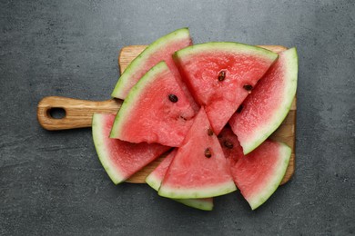 Photo of Slices of tasty ripe watermelon on grey table, top view