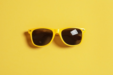 Photo of Stylish sunglasses on color background, top view. Beach accessories