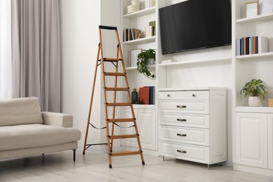 Photo of Wooden folding ladder in stylish living room