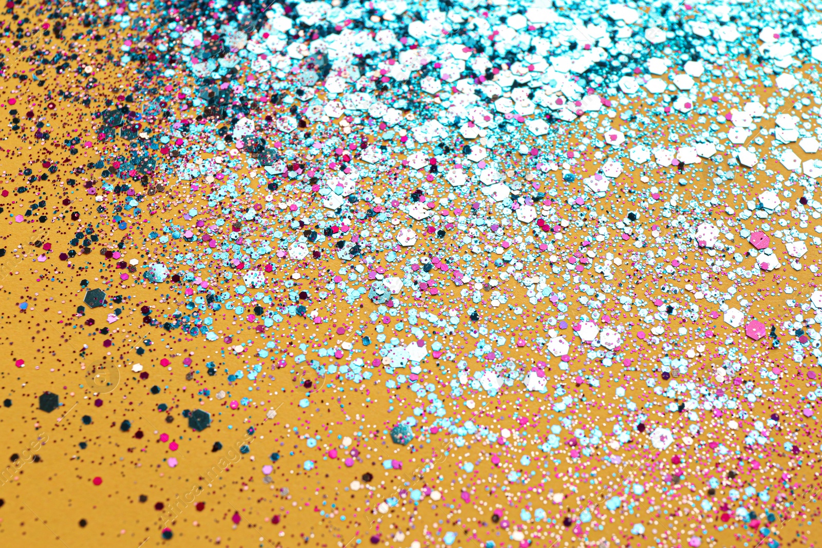 Photo of Shiny bright light blue glitter on yellow background