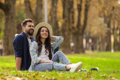 Photo of Beautiful couple spending time together in park. Space for text