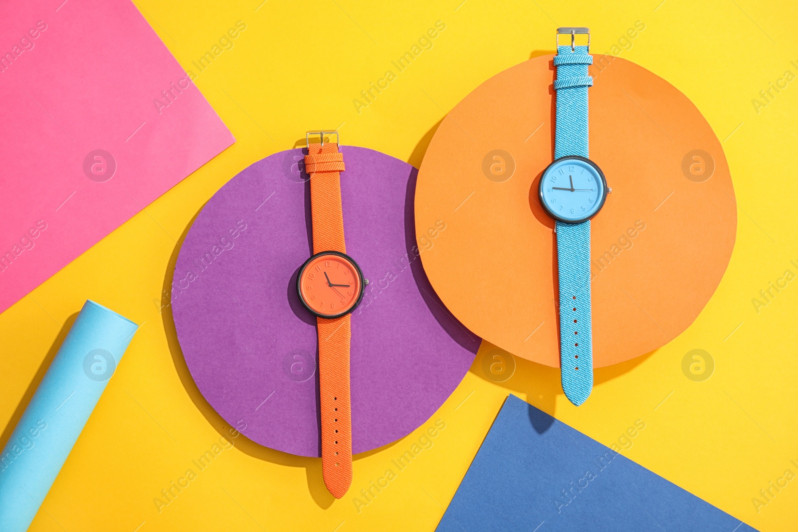 Photo of Composition with stylish wrist watches on color background, flat lay. Fashion accessory