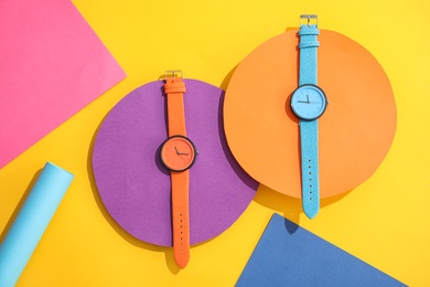 Photo of Composition with stylish wrist watches on color background, flat lay. Fashion accessory