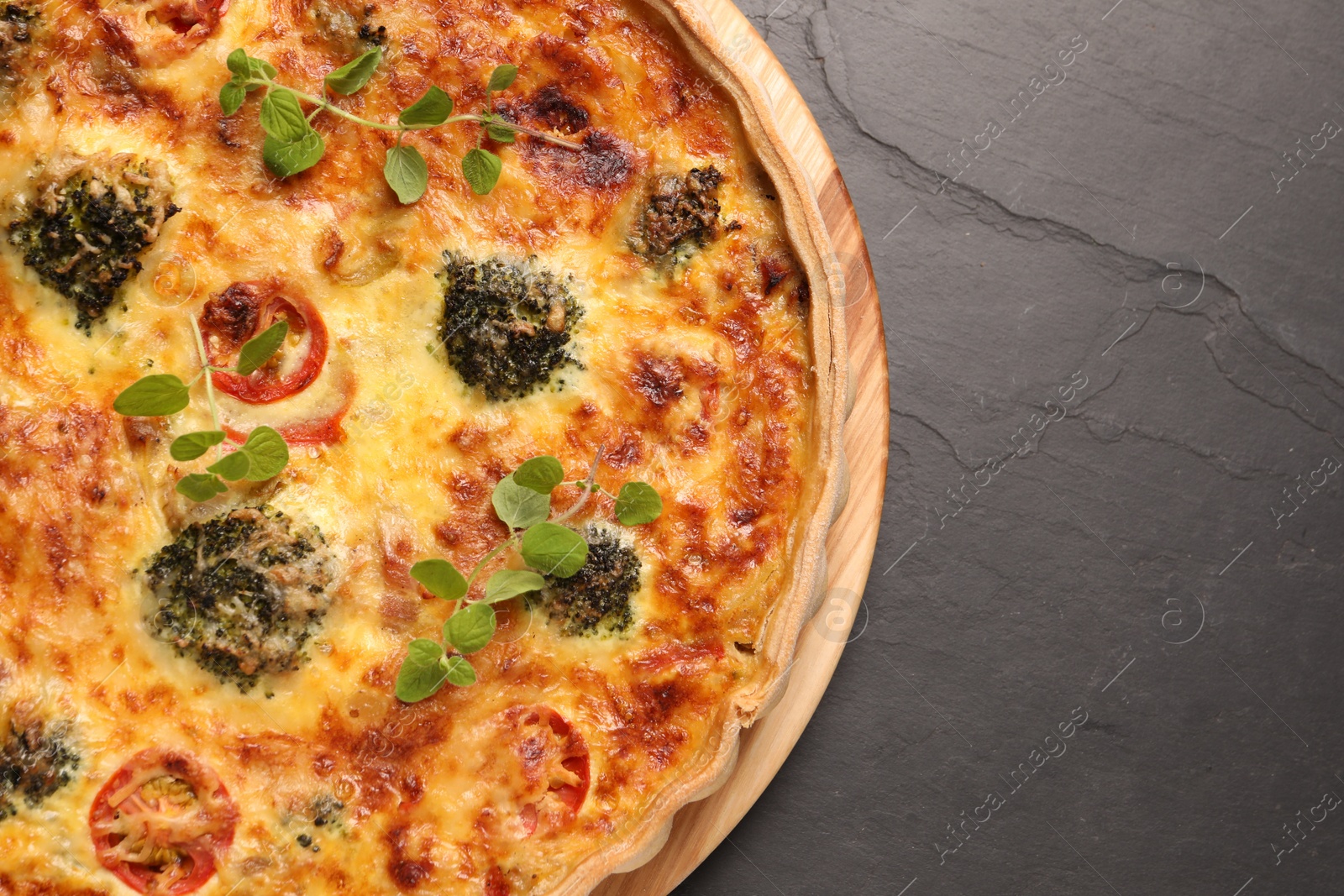 Photo of Delicious homemade vegetable quiche on dark table, top view