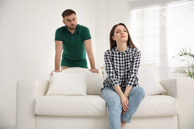 Photo of Unhappy young couple with relationship problems at home