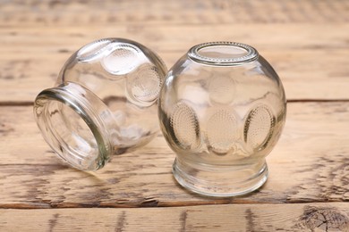 Photo of Glass cups on wooden table, closeup. Cupping therapy