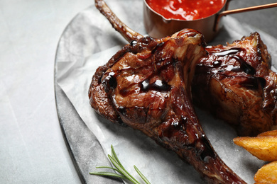 Delicious grilled ribs served on light table, closeup