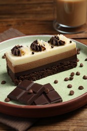 Photo of Piece of tasty mousse cake and chocolate on table