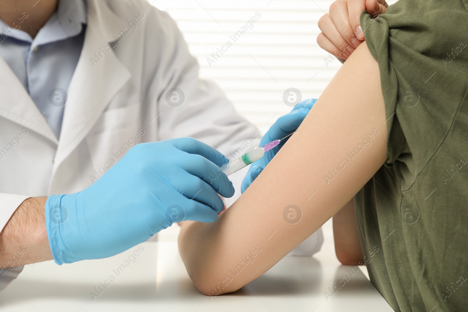 Photo of Doctor giving hepatitis vaccine to patient in clinic, closeup