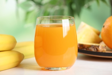 Yummy juice in glass on white table, closeup