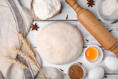 Fresh dough and ingredients on white wooden table, flat lay