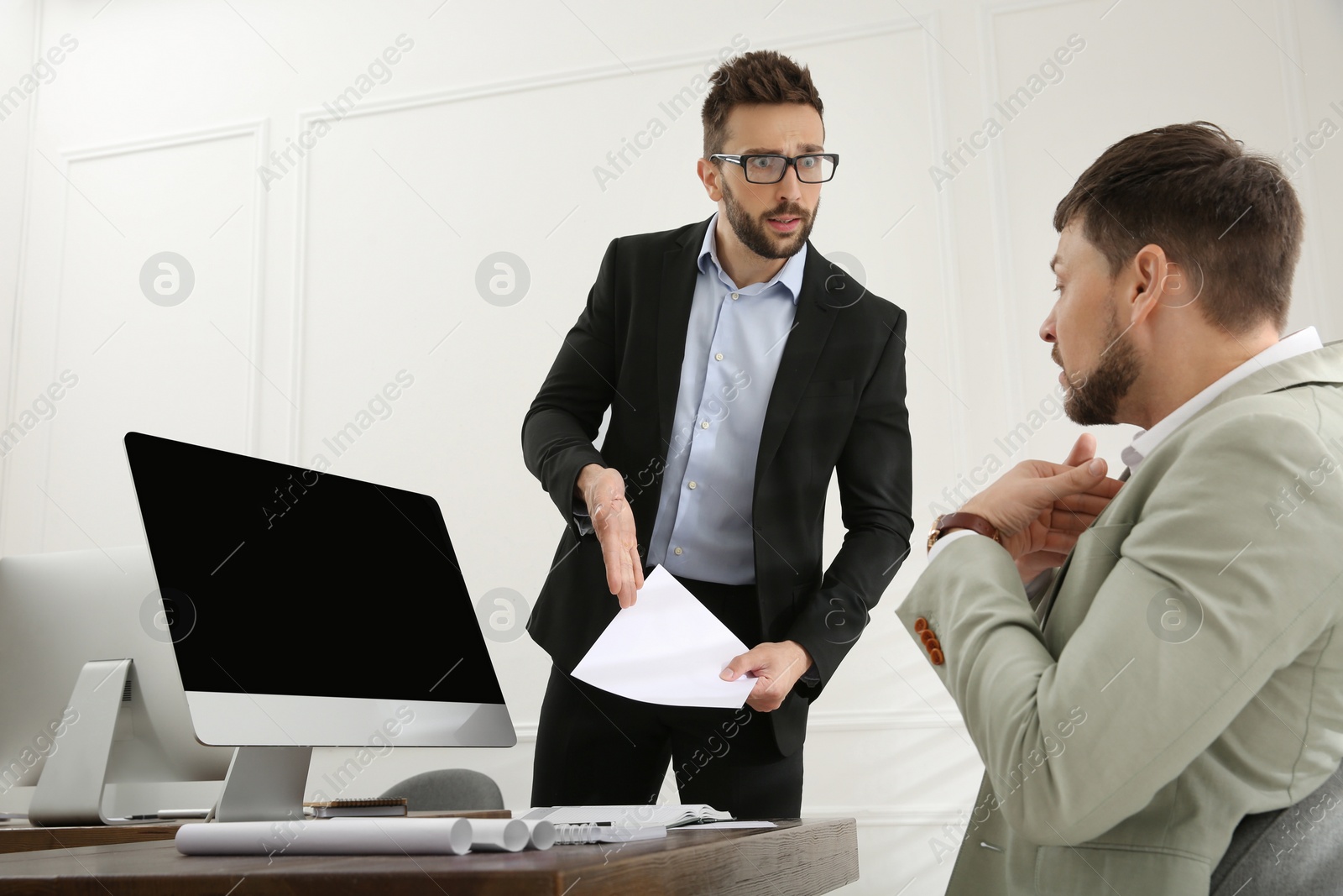 Photo of Boss scolding employee in office. Toxic work environment