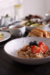 Photo of Oatmeal with fruits and nuts served on buffet table for brunch