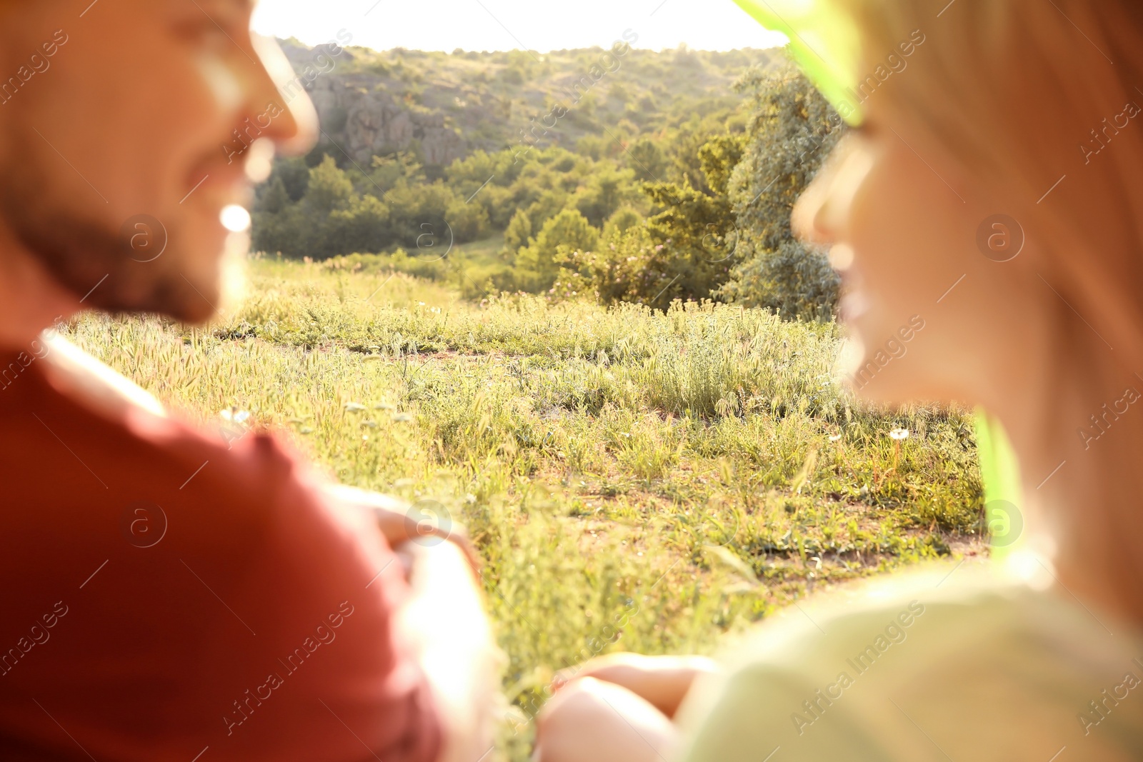 Photo of Lovely couple resting in wilderness. Camping season