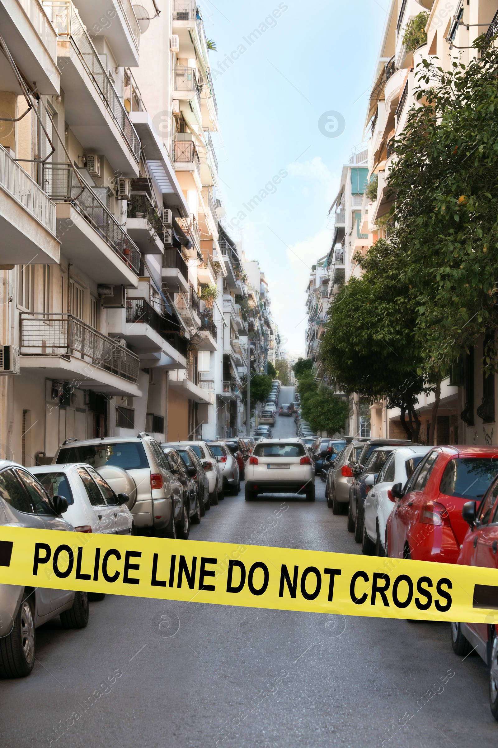 Image of Yellow crime scene tape blocking way on street