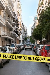 Yellow crime scene tape blocking way on street