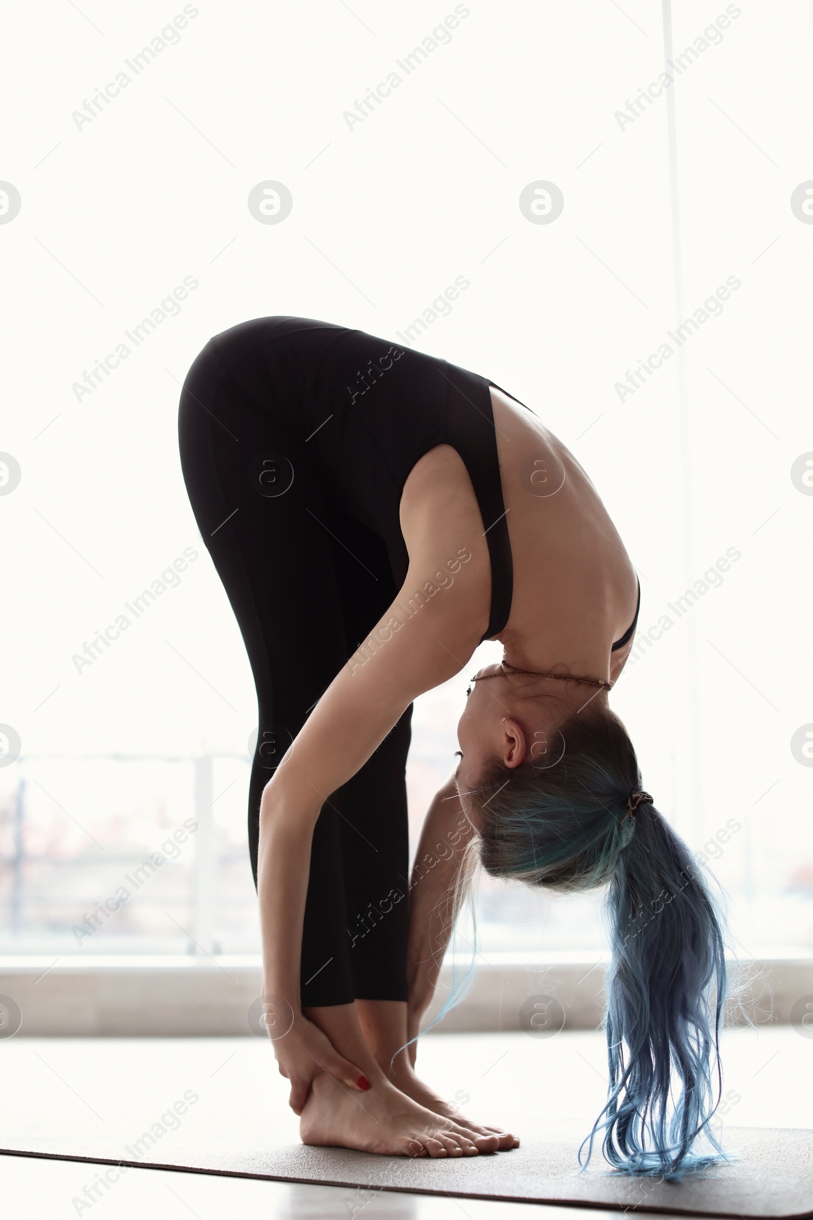 Photo of Young woman practicing yoga indoors