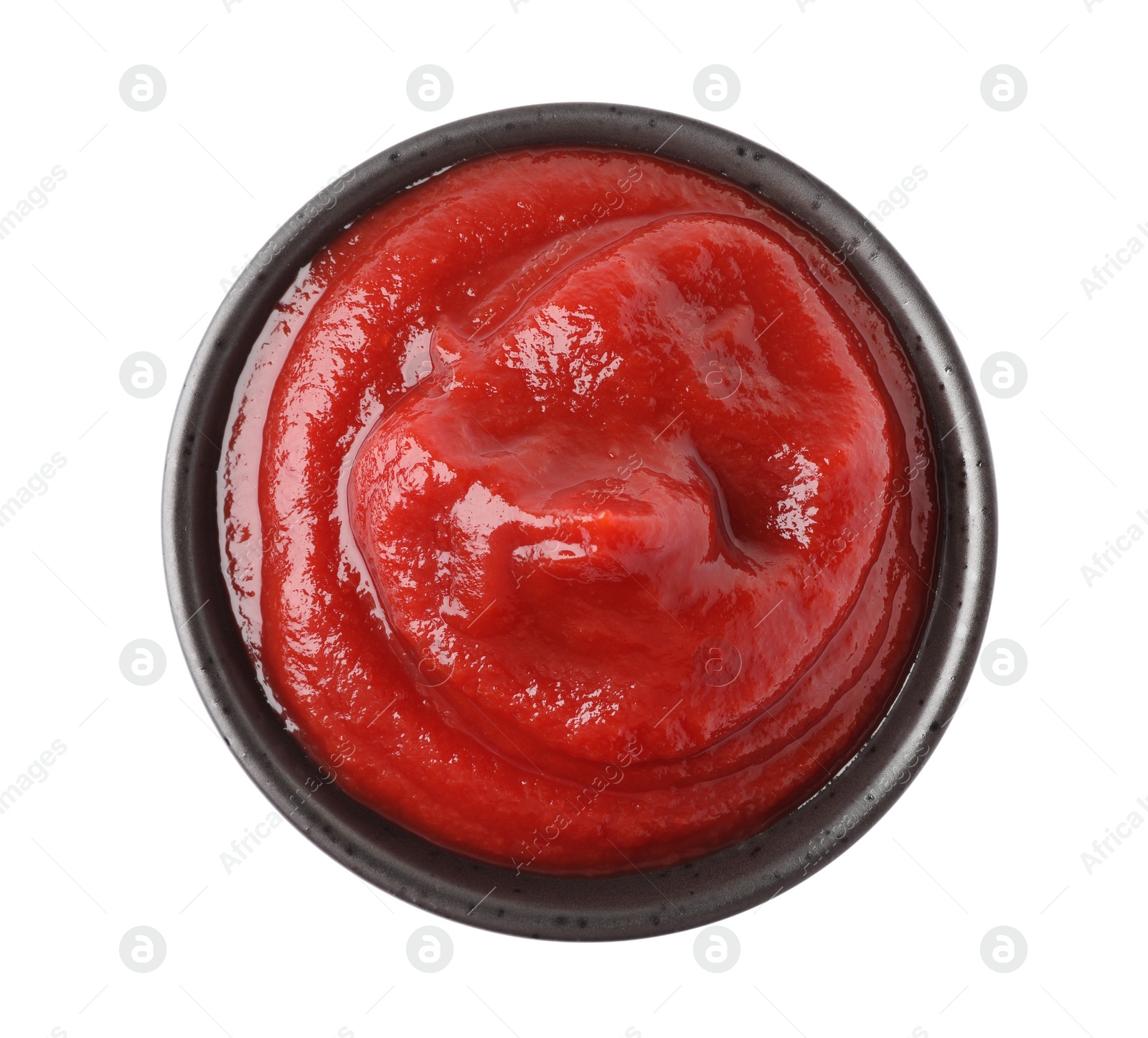 Photo of Tasty ketchup in bowl isolated on white, top view