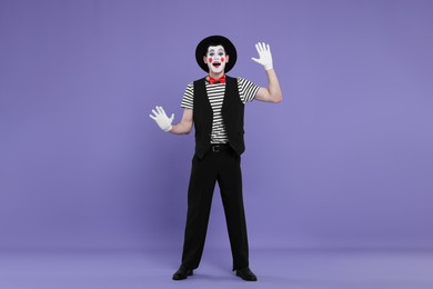 Mime artist making excited face on purple background