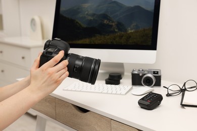 Photographer with camera at white table indoors, closeup