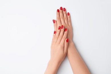 Woman with red polish on nails against white background, closeup. Space for text