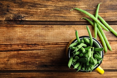 Photo of Fresh green beans on wooden table, flat lay. Space for text