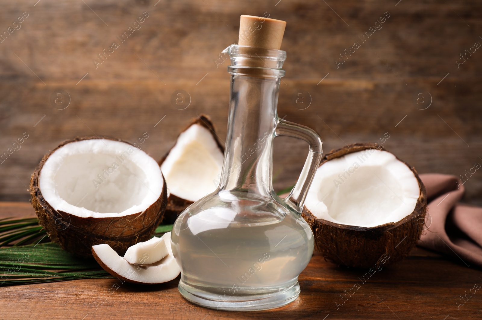 Photo of Coconut oil in glass jug on wooden table