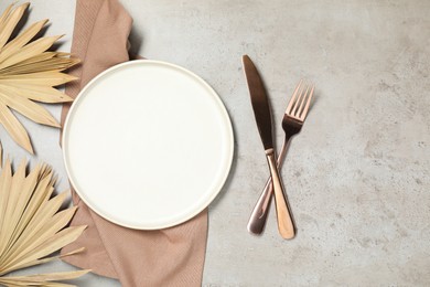 Setting with beautiful cutlery on textured table, top view