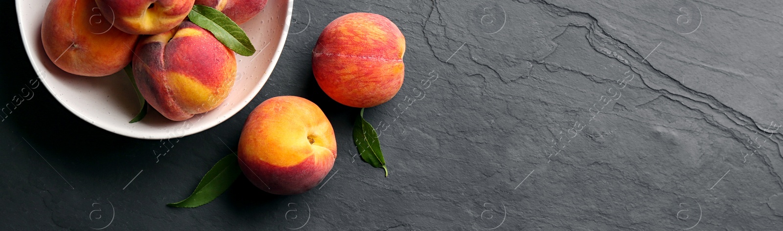 Image of Fresh ripe peaches on black slate background, top view. Banner design with space for text