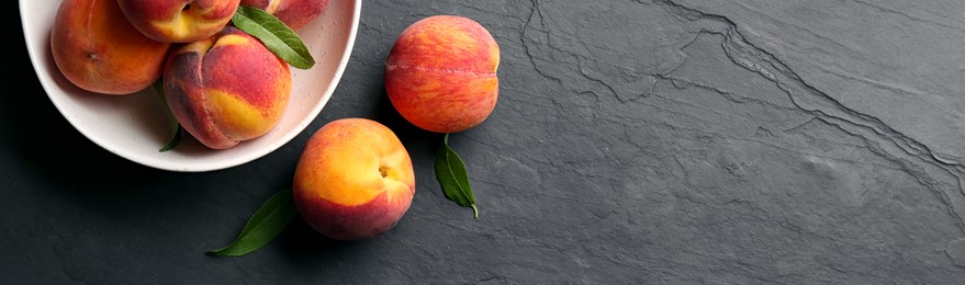 Fresh ripe peaches on black slate background, top view. Banner design with space for text