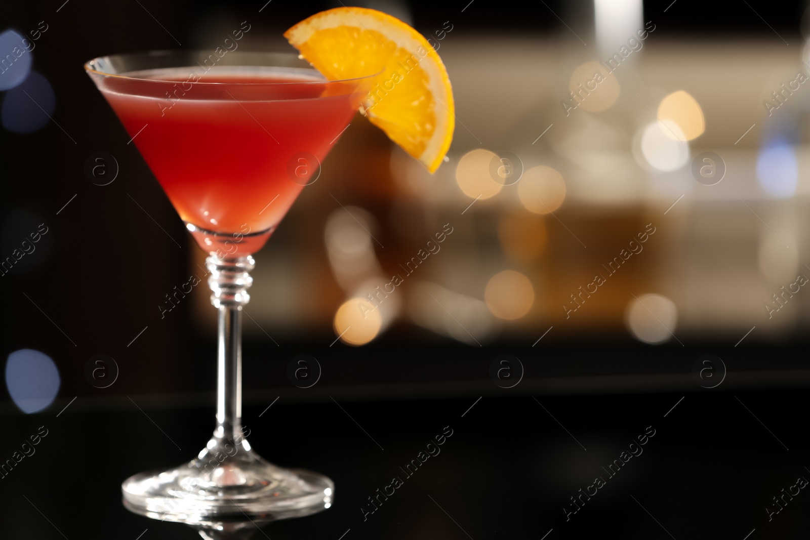 Photo of Delicious cocktail with orange on bar counter. Space for text