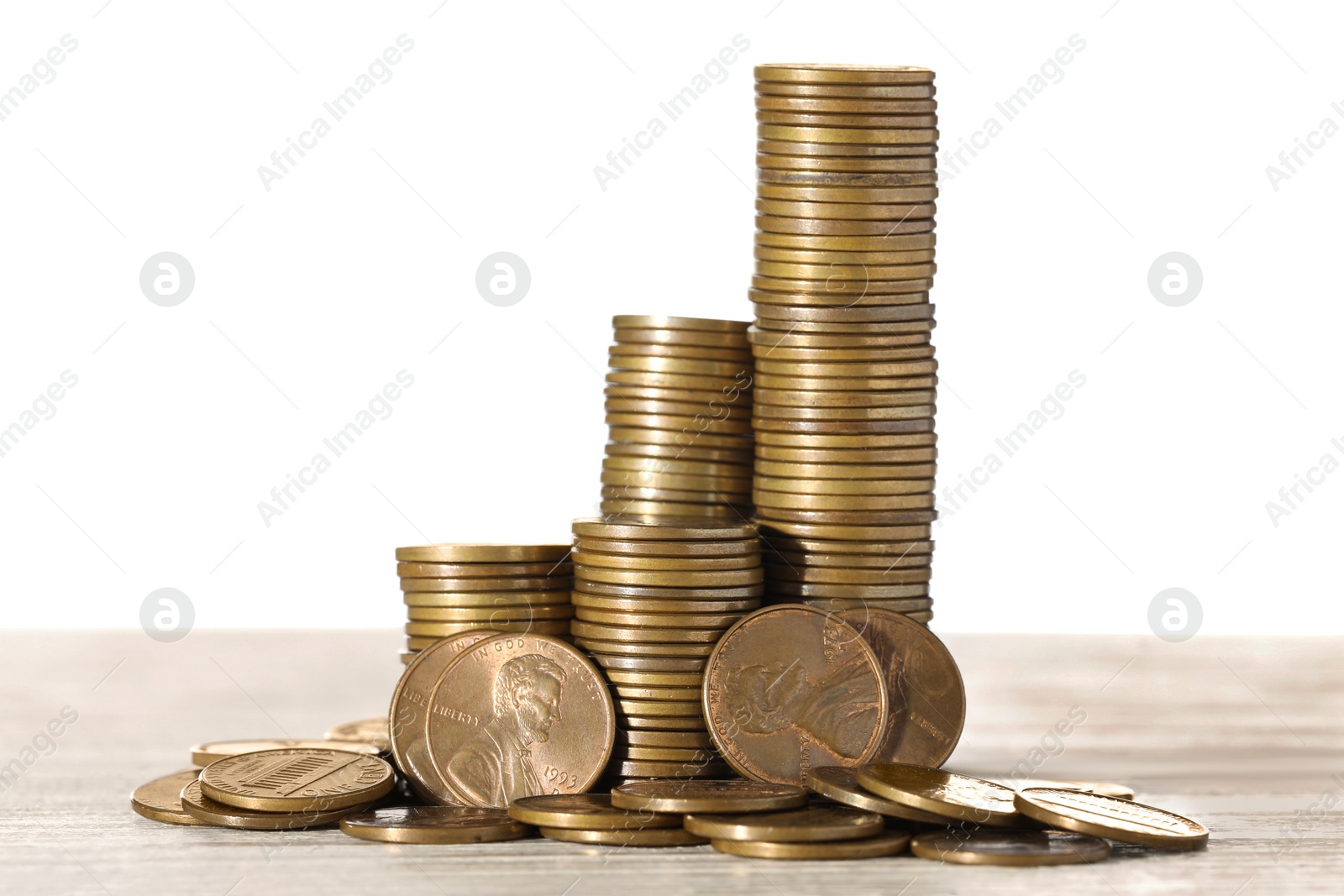 Photo of Stack of coins on wooden table against white background