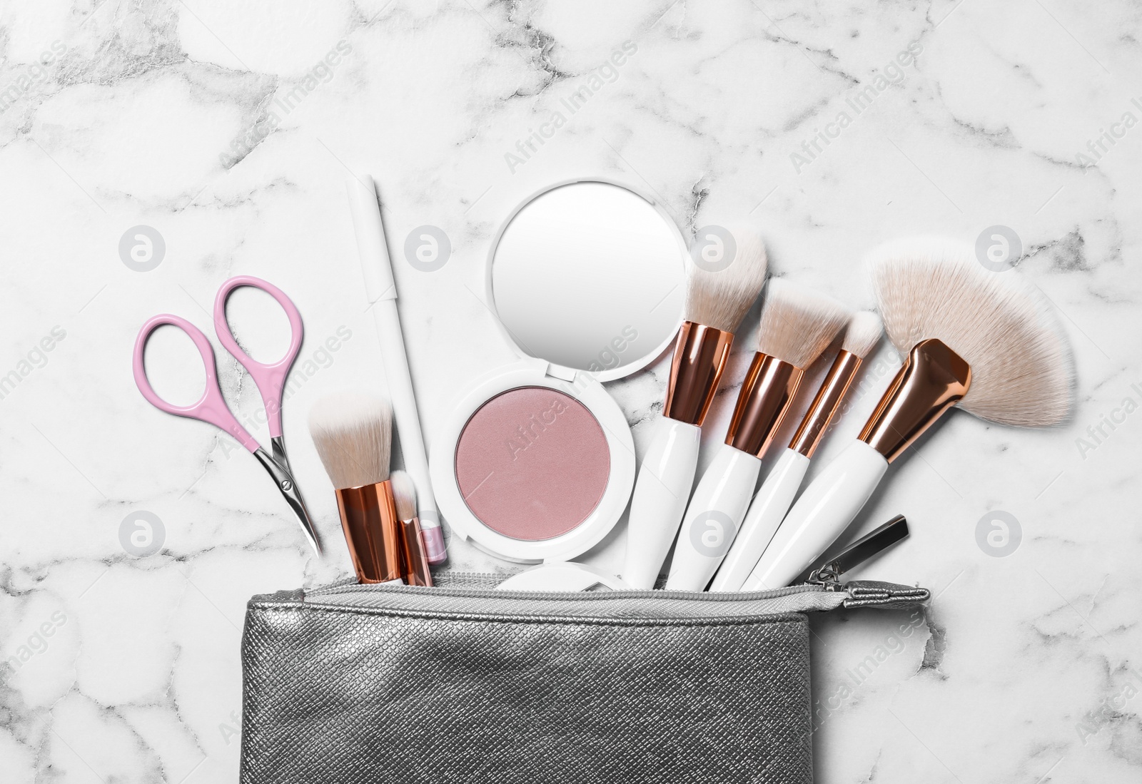 Photo of Cosmetic bag with makeup products and beauty accessories on white marble background, flat lay