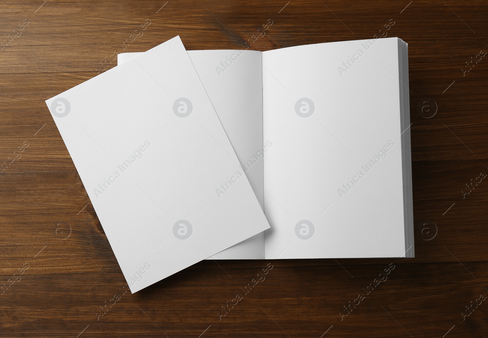 Photo of Sheet of paper and blank brochure on wooden table, flat lay. Mockup for design